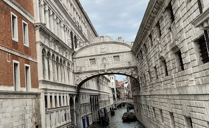 Fotografía del Puente de los Suspiros de piedra blanca entre dos edificios 